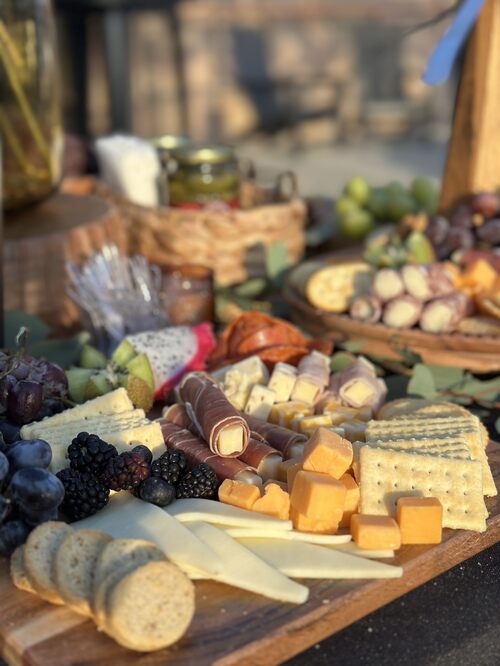 Artisanal cheeses, berries, charcuterie, and bread on the grazing table