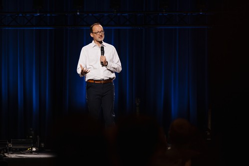 Pastor Paul preaching on the platform at GatheringPoint Church.
