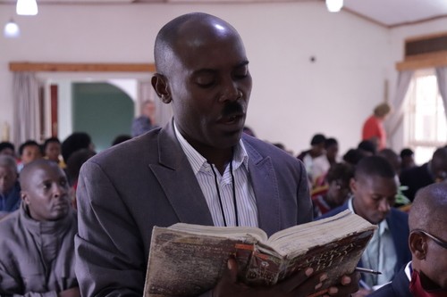 African man reading from a worn Bible