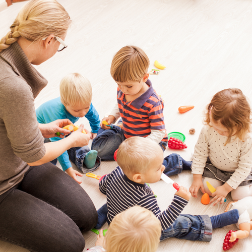 Children Sitting in Chairs Following Instructor