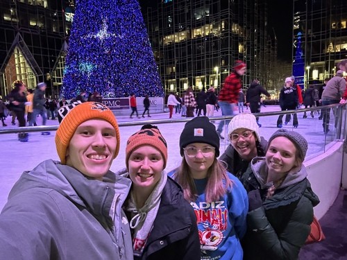 young people are smiling for a photo at an ice skating ring