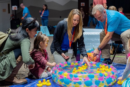 Volunteers helping a mother and child play a game with rubber duckies at the Fall Festival at Creekside Church.