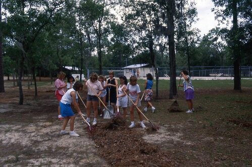 Girls with gardening tools.