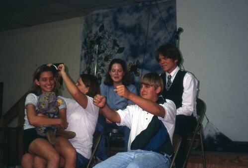 People doing a silly skit in chairs.