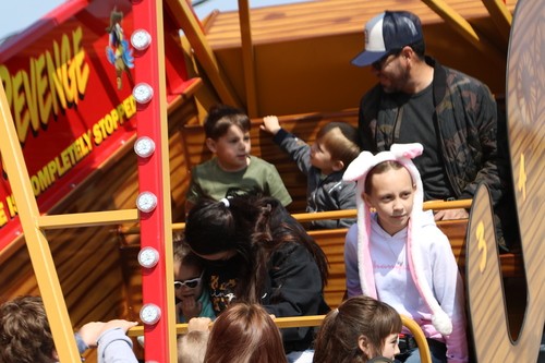 Families enjoy a carnival ride while they wait for Egg Hunt to begin at New Life Church in Oak Grove, MO
