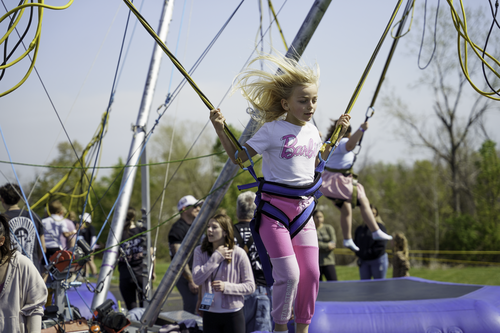 Two girls enjoy free cotton candy while they wait with their Easter baskets for the Egg Hunt to begin at New Life Church in Oak Grove, MO