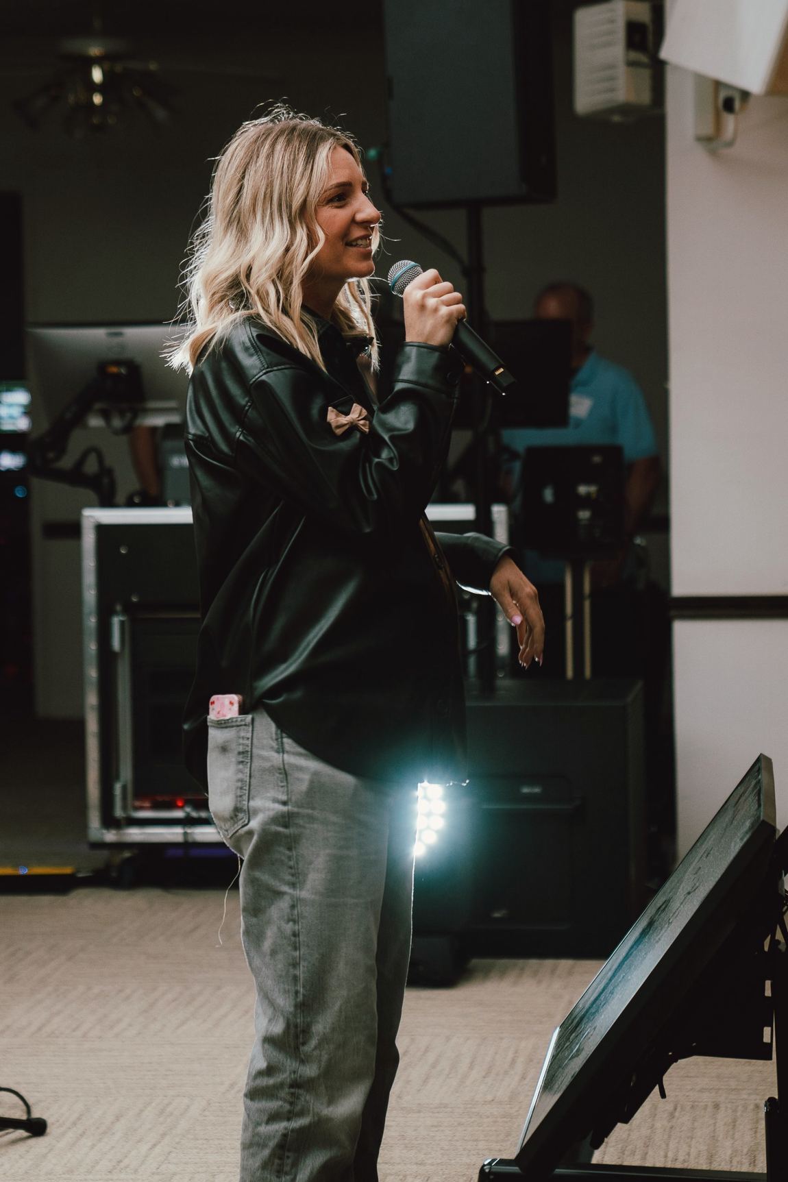 A Life Fellowship Chandler host smiling with a microphone on a Sunday morning