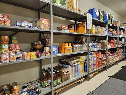 Shelves of food for the MedinaUMC Food Pantry including Apple juice, breakfast ceral, pop tarts, pie filling, and other food.