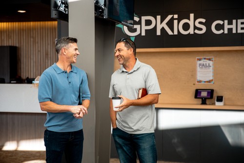 Two men talking in the lobby at Grace Point Church on a Sunday morning