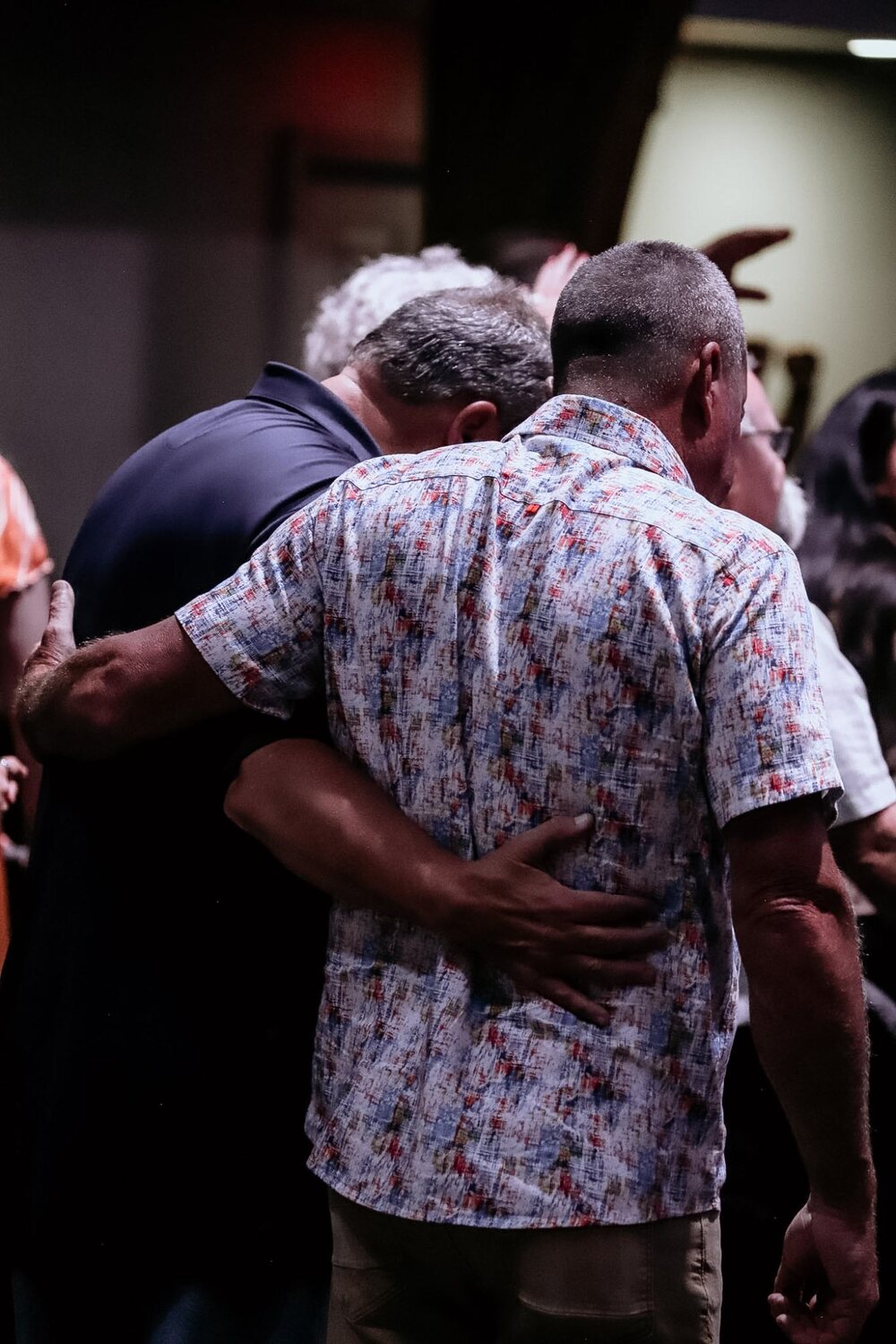 Two people embracing in prayer during a service