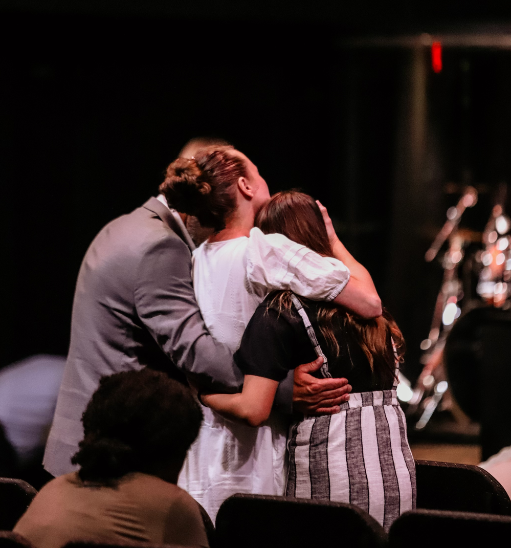 Two people embracing in prayer during a service