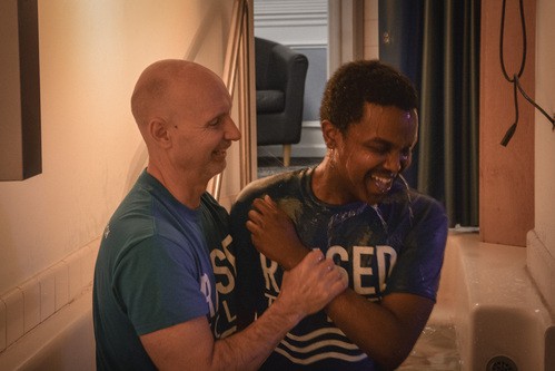 Man being baptized in a tank of water