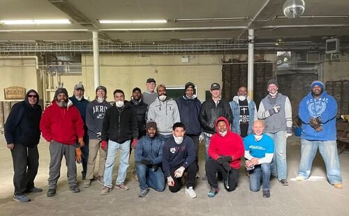 Three men using wood to build a new wall