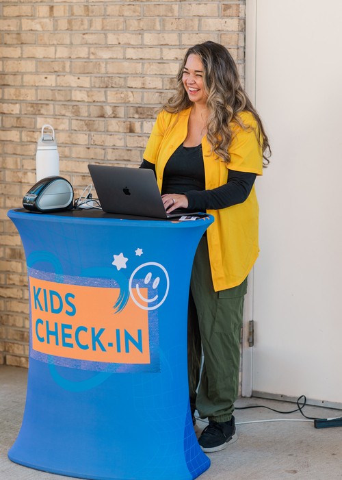 Vivid City Kids volunteer helping with secure kids check-in at Vivid City Church Greensboro NC