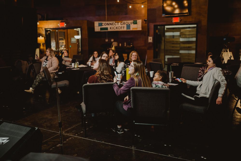 Young adults gathered around tables for community night