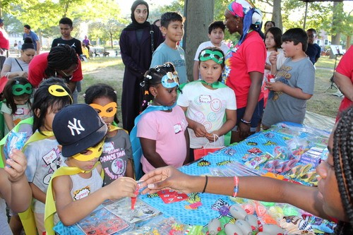 Kids choosing small prizes from the Vacation Bible School reward table after completing activities.