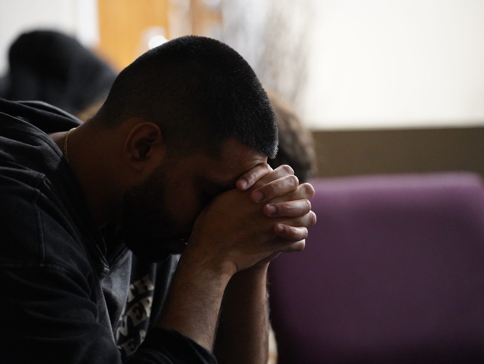 A man praying quietly with his head bowed at Calvary Life Brooklyn
