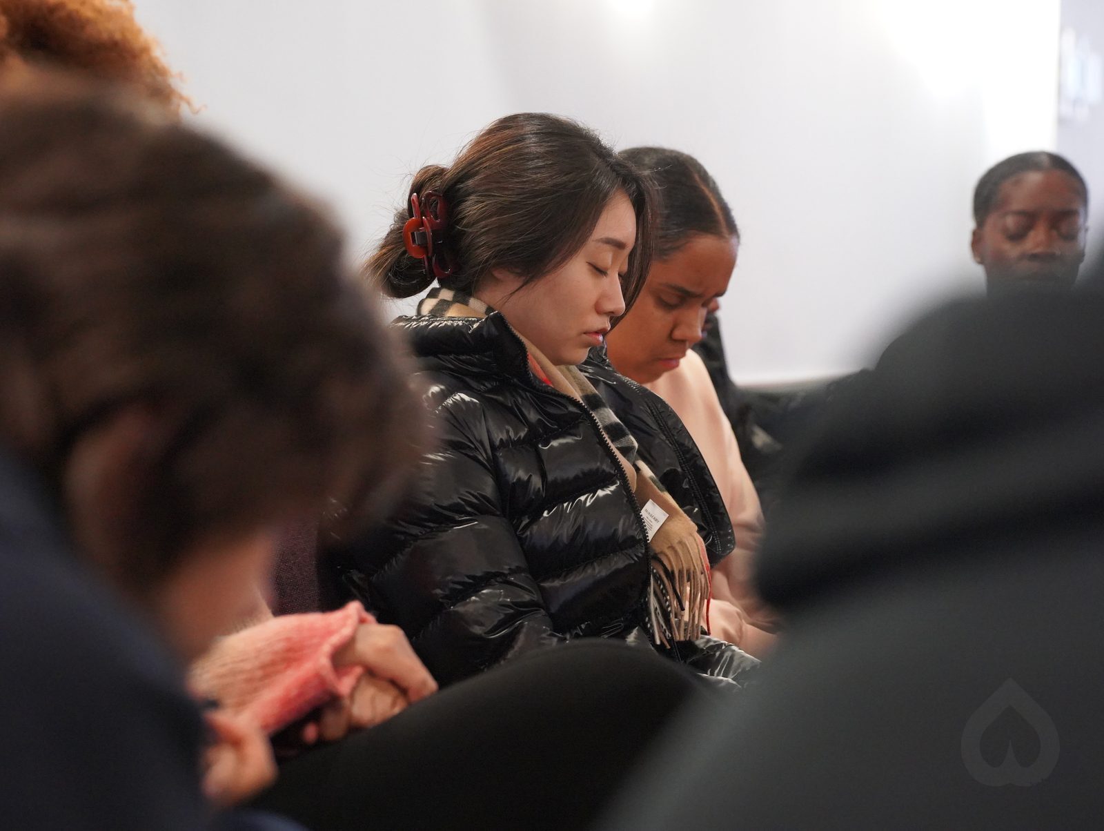 People seated with heads bowed in prayer during a service at Calvary Life Brooklyn