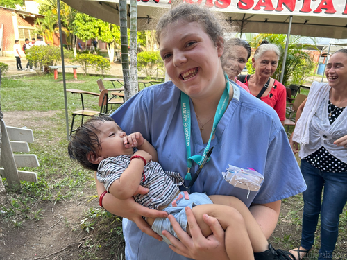 Volunteer on Honduras Medical Mission trip holding a baby