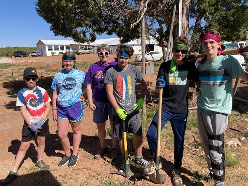 group of youth and adult adviser on youth mission trip pausing from work