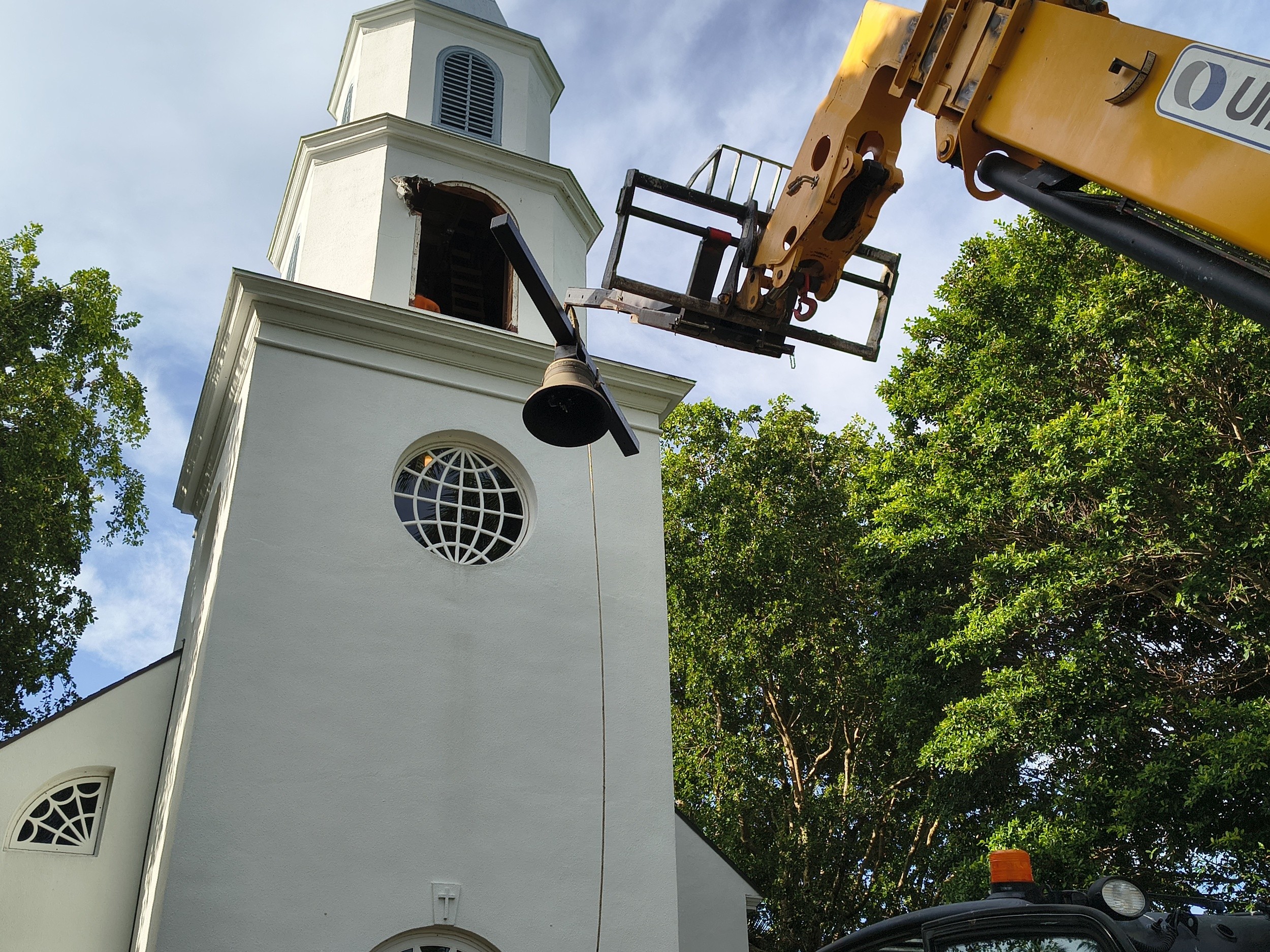 A bell being carefully removed from the Trinity-by-the-Cove tower