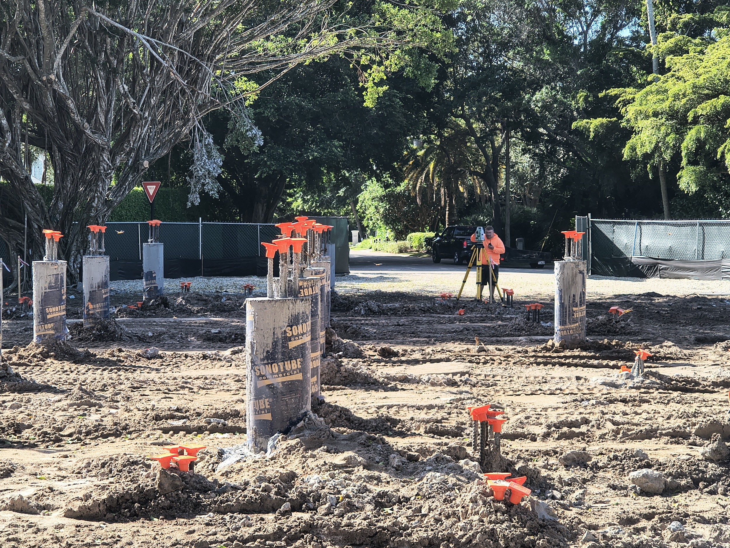 Surveyor checking measurements among the completed foundation pilings