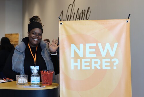 Church member waving to new visitors interested in learning about God in Fredericksburg