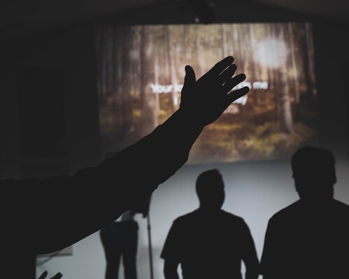 photo of attendees worshipping with their hands up