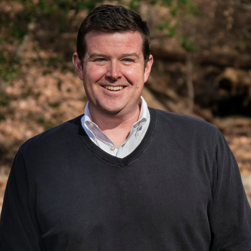 John McGowan, lead pastor of Restoration City Church, smiling outdoors in casual dress.