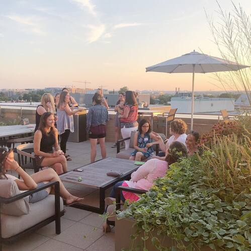 &ldquo;Women from a Restoration City Church community group enjoying conversation during a rooftop gathering at sunset.