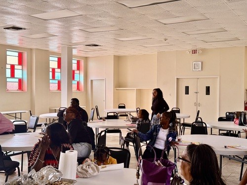 Young adults meet and greet session. Young adults sitting and standing together in the fellowship hall.
