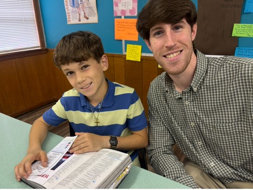 leader and child with open Bible