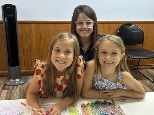 woman with two little girls at church