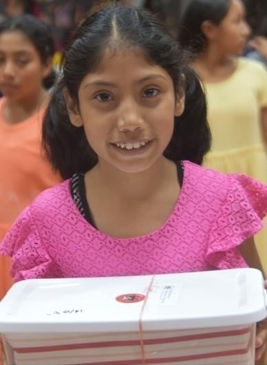 little girl holding Christmas shoe box