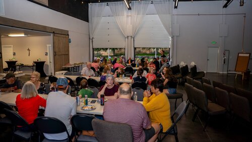 The hall full of people sharing a meal together