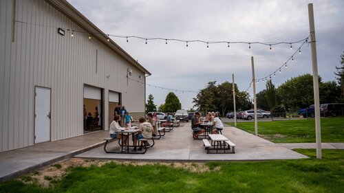 Picnic tables and string lights outside Westridge Church on a summer evening
