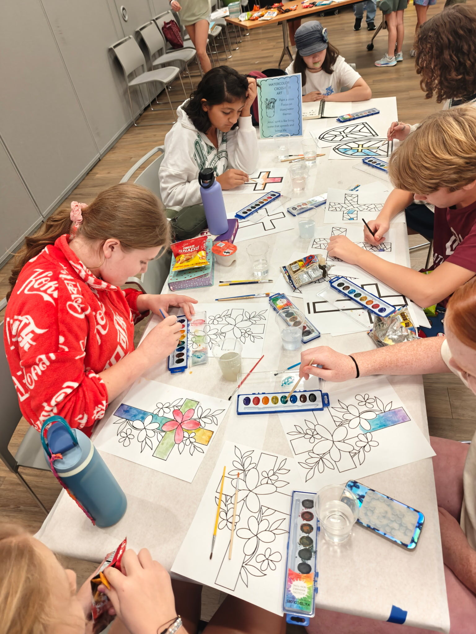 Students painting watercolor crosses together