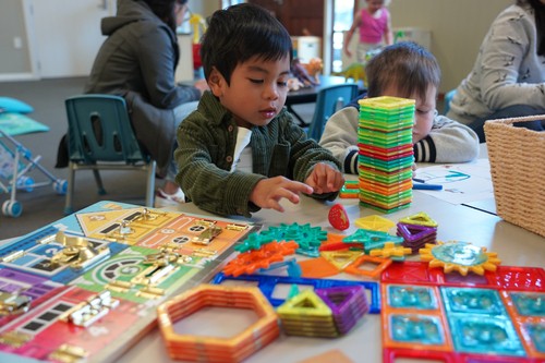 Children playing with colorful building toys and puzzles during a kids&rsquo; program at church.