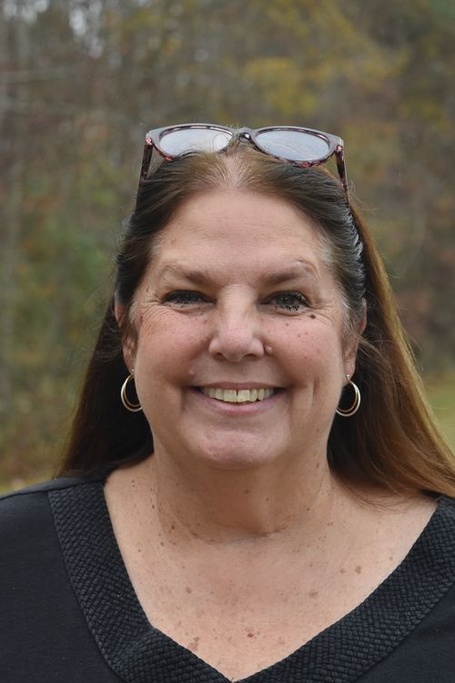 headshot of woman with trees in background