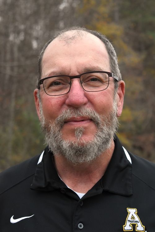 headshot of man with grey shirt