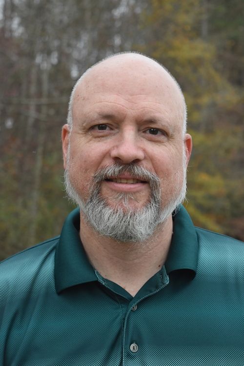 photo of man with trees in the background