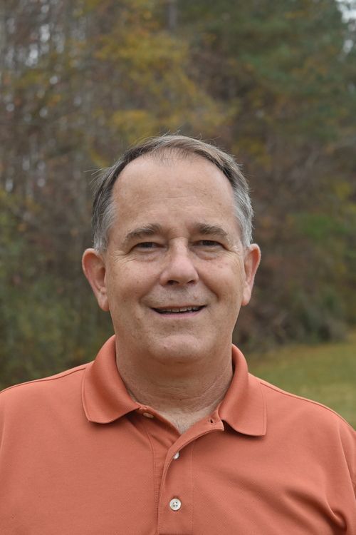 headshot of man with trees in background