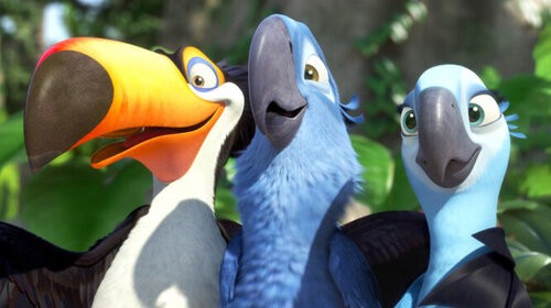 A picture of a scene from the movie Rio. It features three birds. From left to right there is a tucan with a large orange beak, a blue parrot in the middle with a large black beak, and a smaller blue parrot on the right with a smaller black beak. The scene shows all three birds standing looking at something with their wings over each other such as friends do for pictures. 