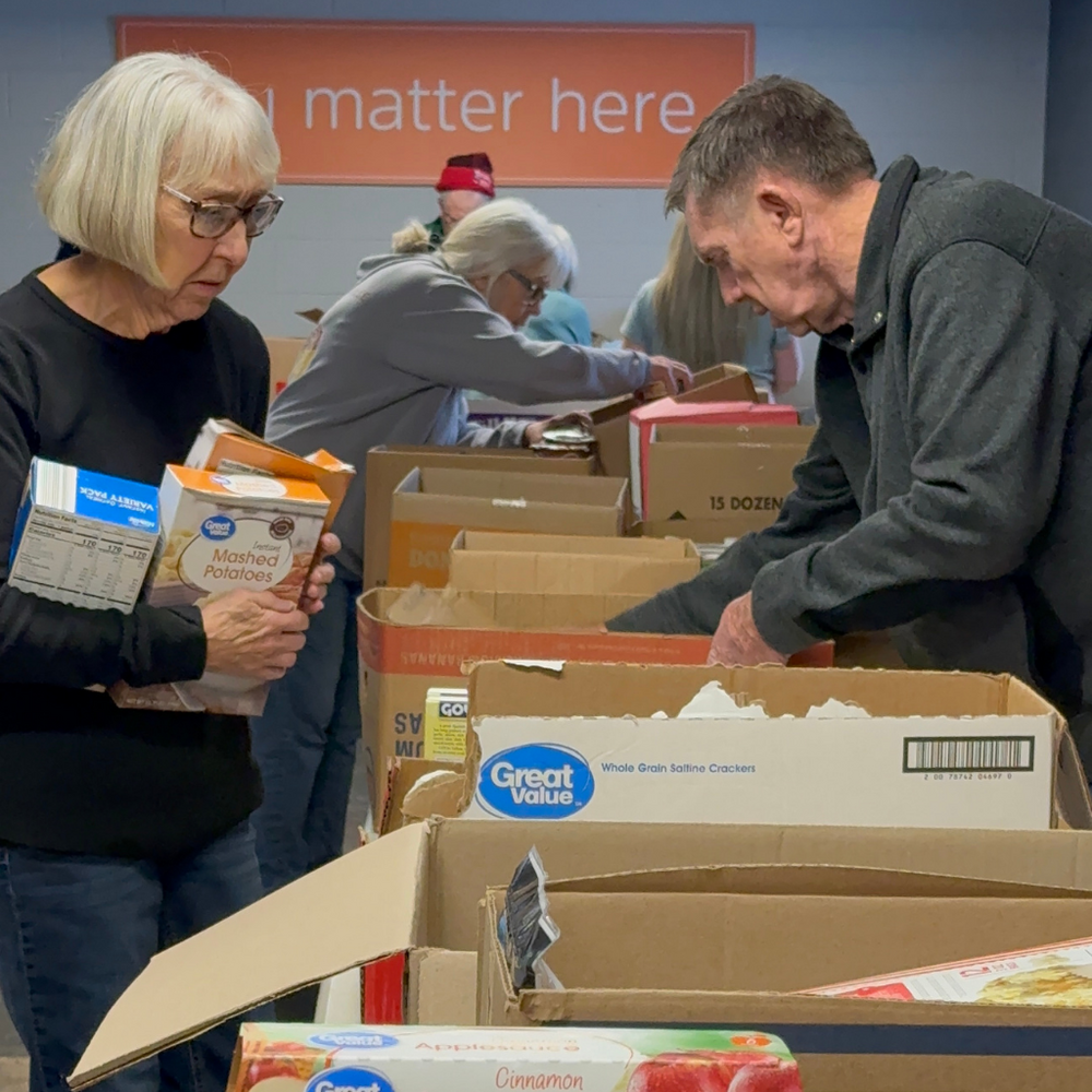 Voluntarios preparando cajas de alimentos para la comunidad