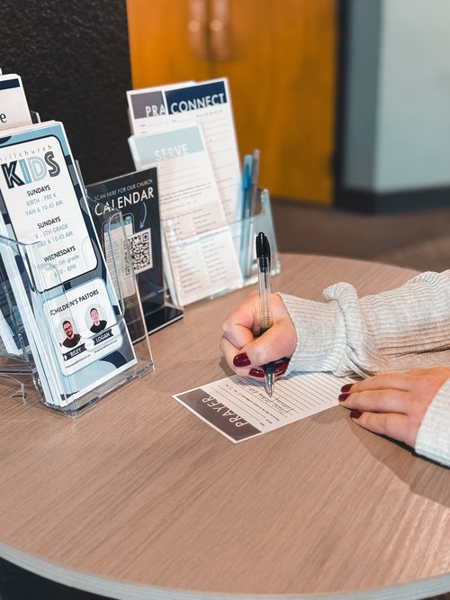 Person filling out a prayer card