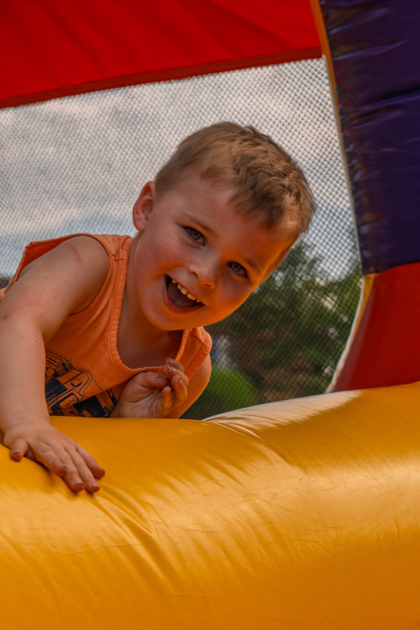 A boy laughing on a bounce house
