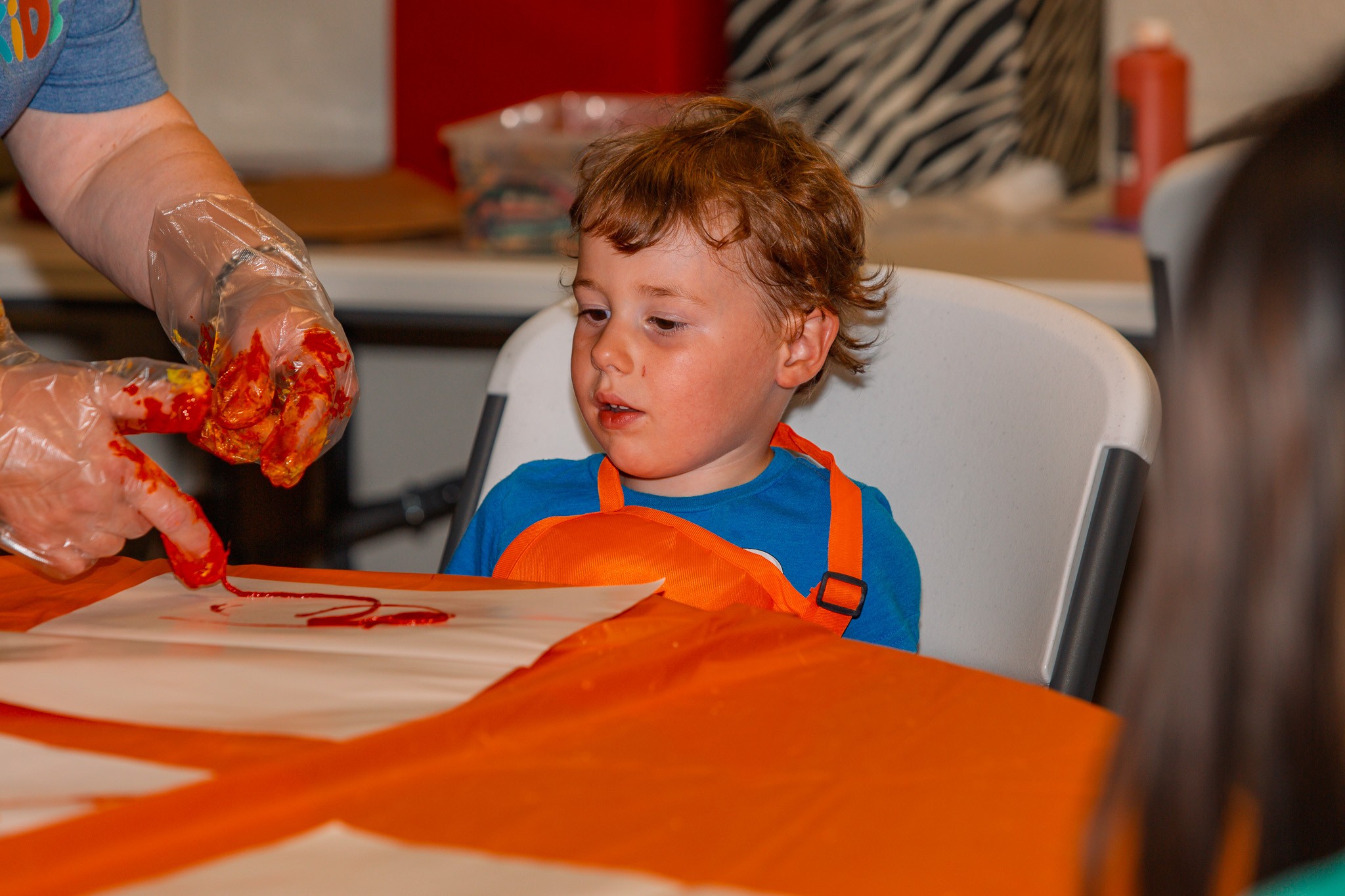 A young boy finger painting