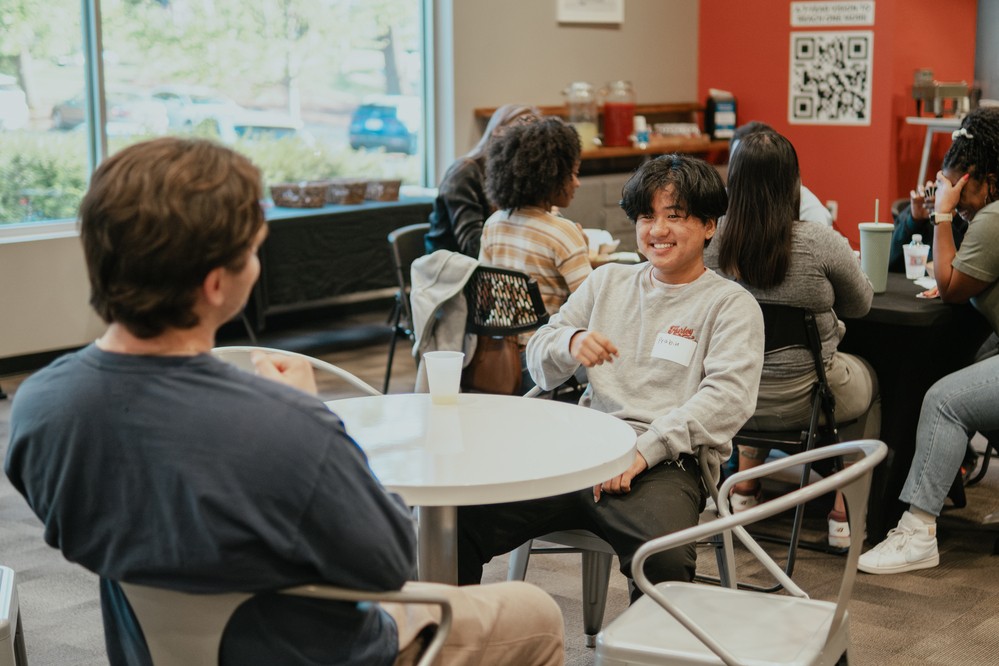 A small group of young adults seated and talking together