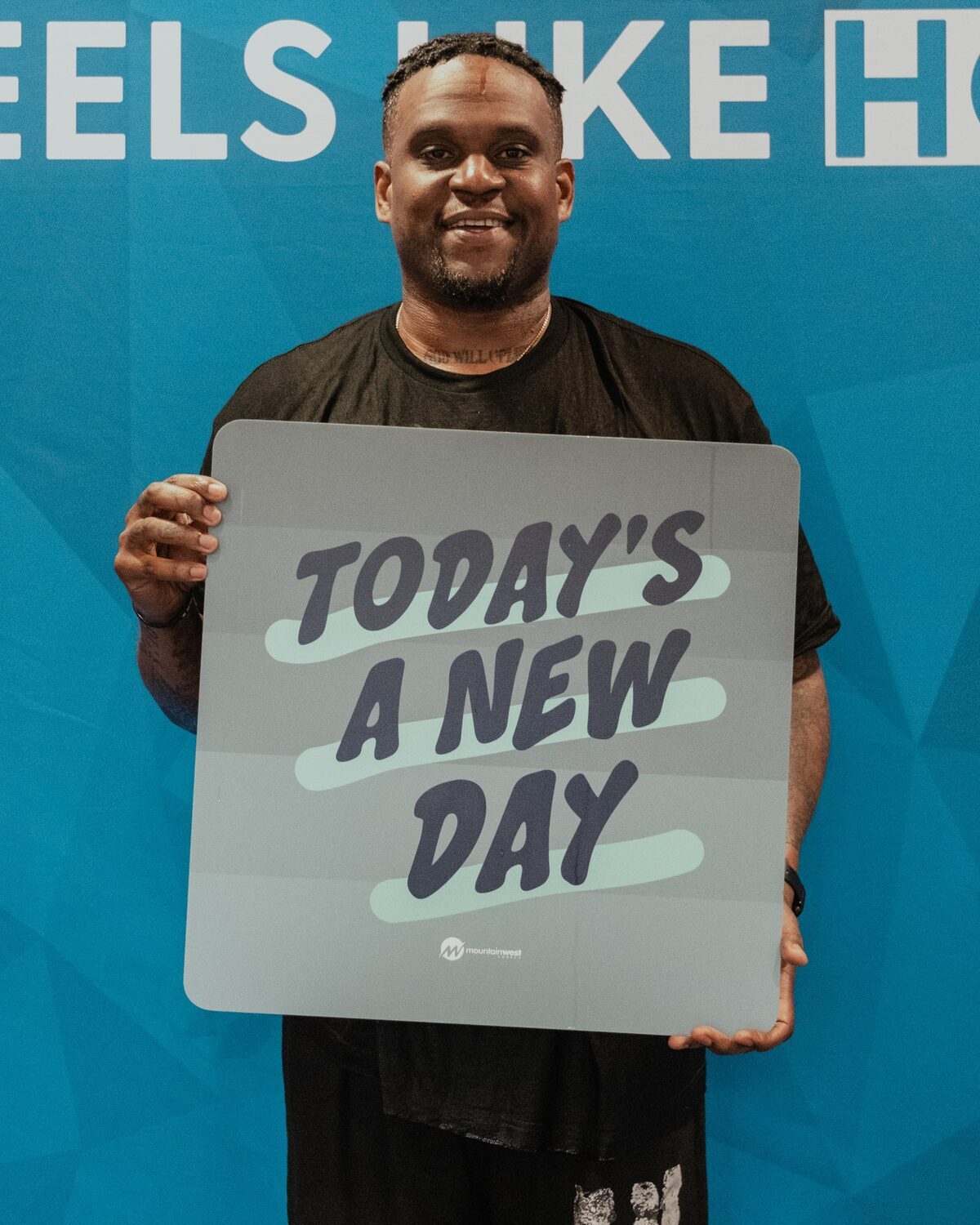 A man holding a sign reading Today’s a new day