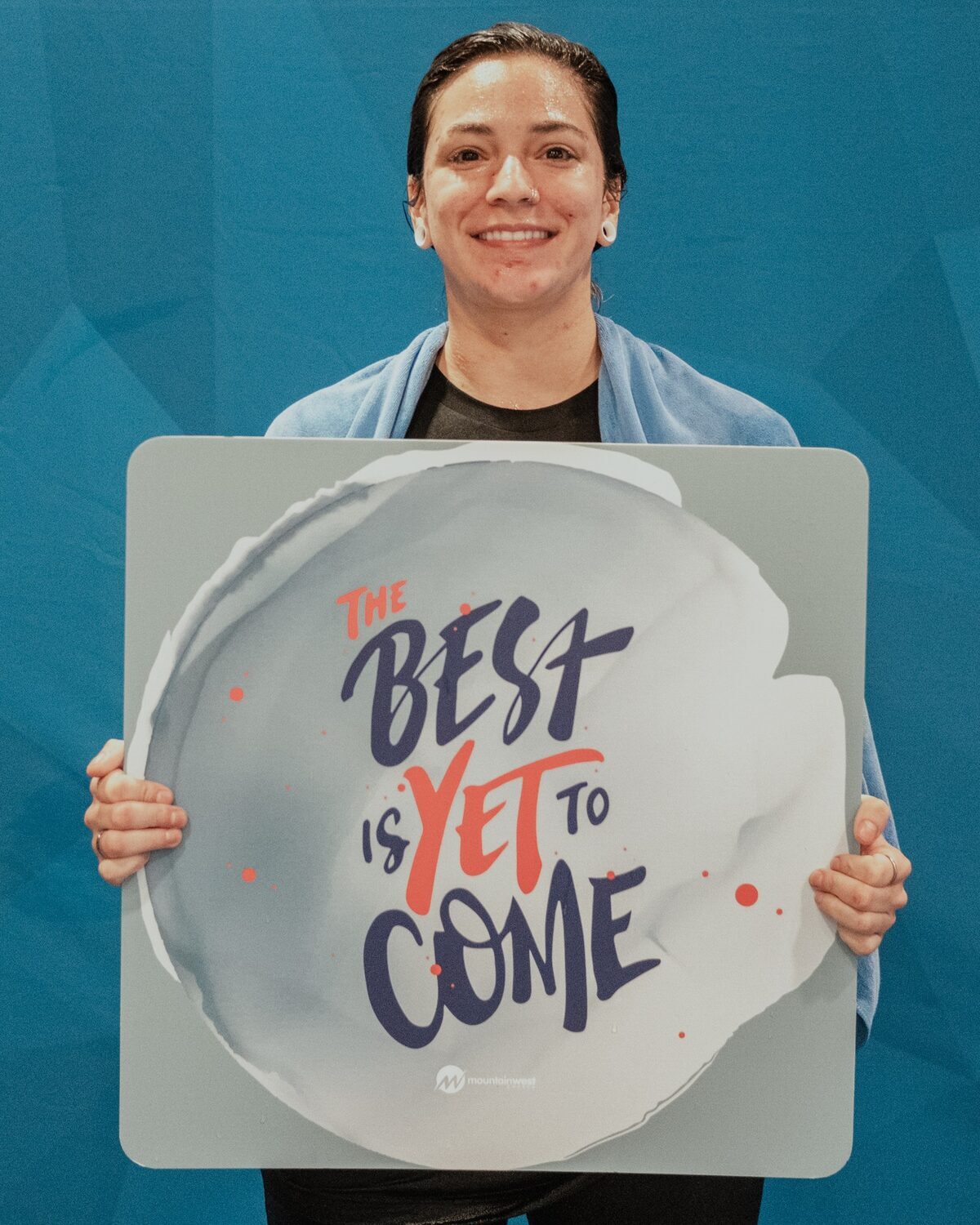 A woman holding a sign reading The best is yet to come